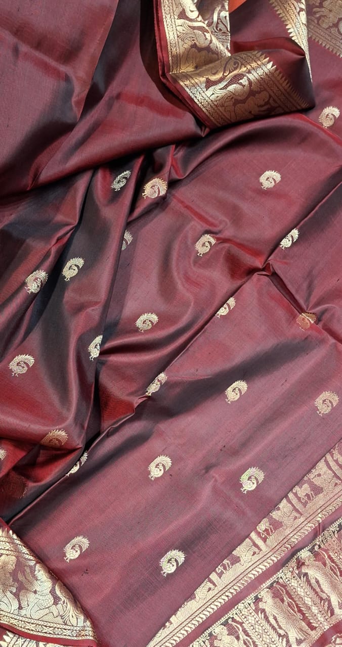 Red and chocolate dual tone peacock motif Swarnachari resham saree with golden zari. Red and chocolate dual tone peacock motif Swarnachari resham saree with golden zari.
