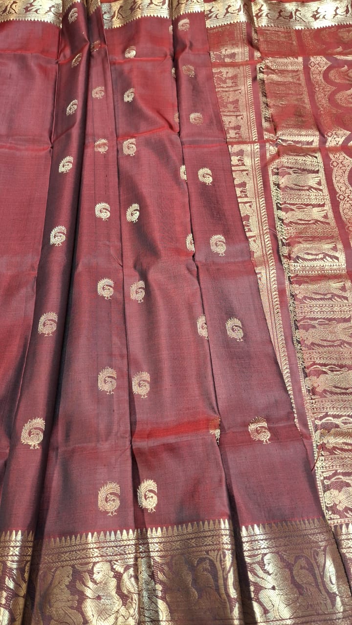 Red and chocolate dual tone peacock motif Swarnachari resham saree with golden zari. Red and chocolate dual tone peacock motif Swarnachari resham saree with golden zari.